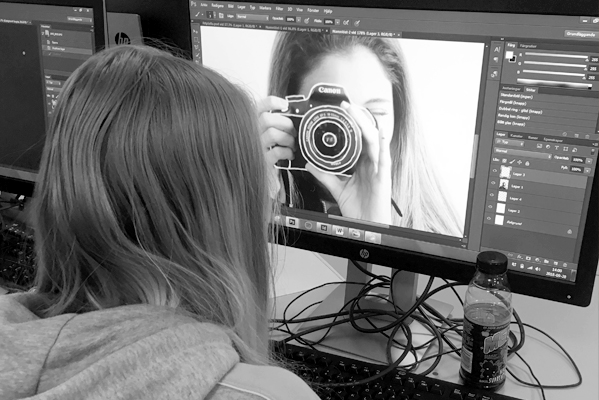 Estet elev arbetar med foto i dator